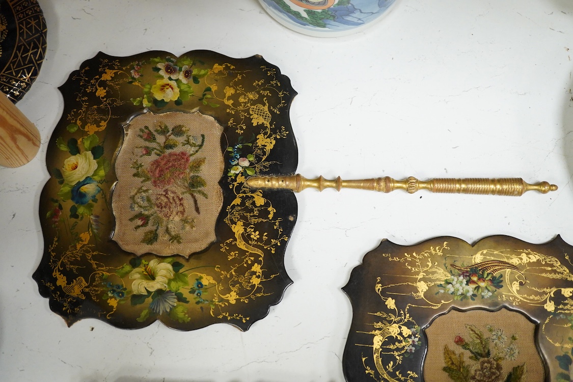 A pair of early Victorian papier maché hand screens, each with embroidered with cross stitched flowers, 41cm in length